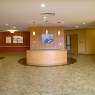 A spacious and well-lit lobby area featuring a reception desk and comfortable flooring.