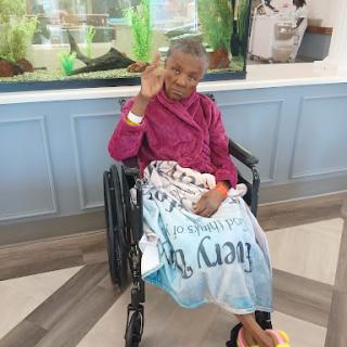 A cheerful child in a wheelchair giving a peace sign, showcasing resilience and positivity.