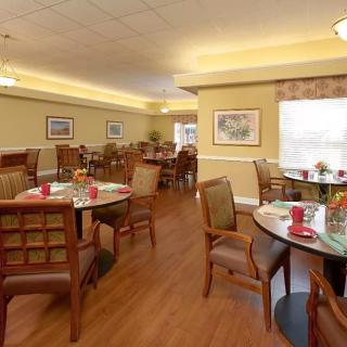 Cozy dining area with neatly arranged tables and chairs, featuring warm decor.
