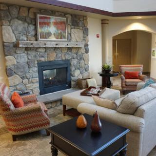 A cozy living room featuring a stone fireplace, comfortable seating, and stylish decor.