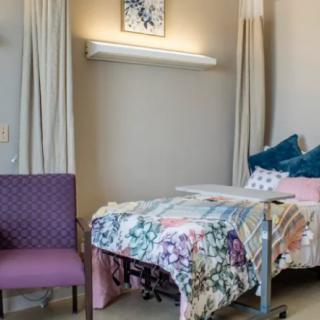 A well-decorated hospital room with a bed and chair.
