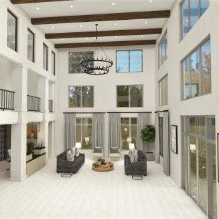 A spacious, modern living room with high ceilings and large windows, featuring contemporary furniture and a central chandelier.