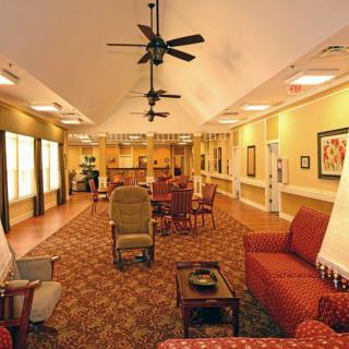 A spacious living area with comfortable seating, ceiling fans, and warm lighting.