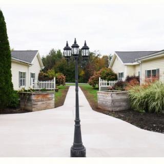A symmetrical view of a pathway flanked by two buildings and centered with a classic lamp post.