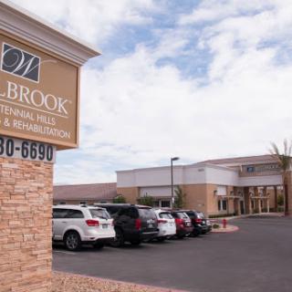 Exterior view of a healthcare facility with visible signage and a parking area.