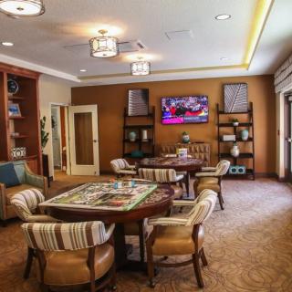 A cozy living room with a table and chairs, TV, and bookshelves.