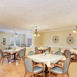 A bright and welcoming dining room with elegantly set tables and comfortable chairs.