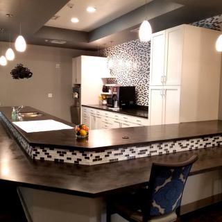 A modern kitchen with stylish backsplash and pendant lighting.