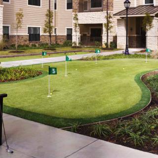 An outdoor mini-golf putting green at an apartment complex.