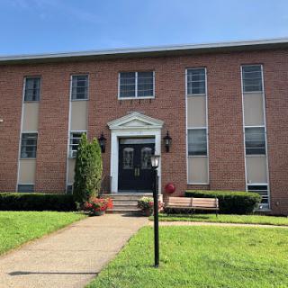 A well-maintained brick building with a welcoming entrance and green landscaping.