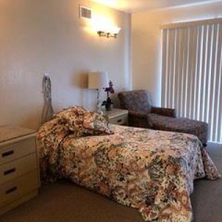 A cozy bedroom with floral bedding and a comfortable chair.