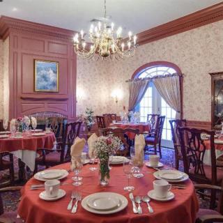 An elegant restaurant dining room with classic decor and a beautifully set table.