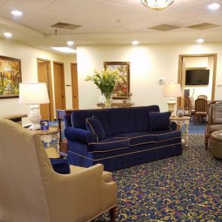 A cozy living room with a blue sofa, armchair, and decorative elements.