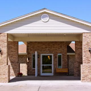 The inviting entrance of a brick building under a clear blue sky.