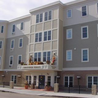 A modern apartment building with multiple floors and large windows.