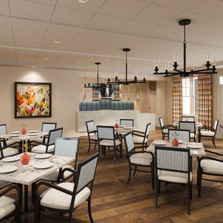 A modern restaurant dining area with elegantly set tables and soft lighting.