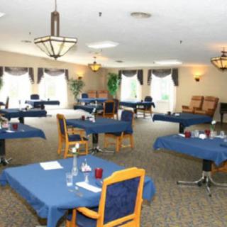 An elegantly set dining room with blue tablecloths and neatly arranged seating.