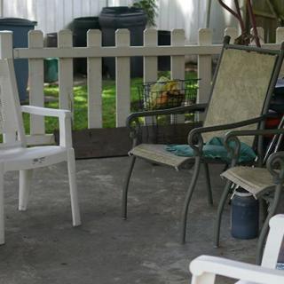 A cozy outdoor patio area with chairs and a view of the backyard garden.