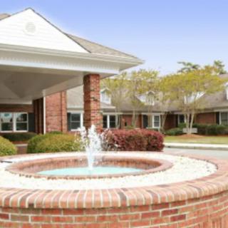 A suburban building with a brick fountain in the foreground.