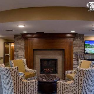 A cozy seating area with armchairs arranged around a fireplace.