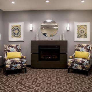 A cozy living room featuring modern furniture, a fireplace, and decorative artwork.