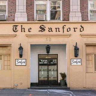 The entrance to The Sanford hotel with decorative signage and lighting.
