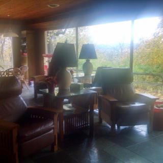 A cozy living room with armchairs and lamps, featuring a large window view.