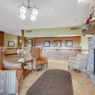 A cozy hotel lobby with seating, a reception desk, and a fireplace.