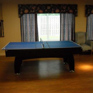 An indoor recreation room with a blue ping pong table.