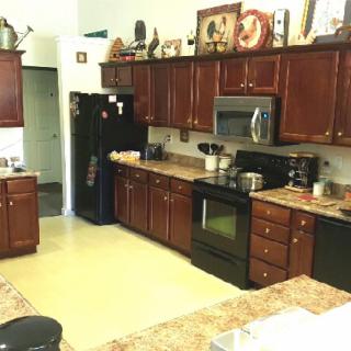 A spacious kitchen featuring dark wood cabinets and modern appliances.
