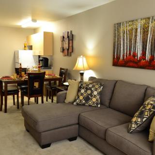 A cozy living room with a sectional sofa and an adjacent dining area.