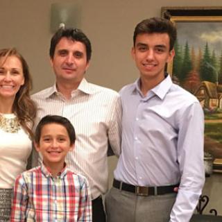 A family posing together indoors, all smiling for the camera.
