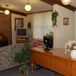 Cozy living room with a desk, couch, and brick fireplace.