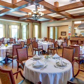 A spacious and elegantly designed dining room with neatly arranged tables and chairs.