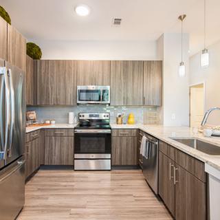 A modern kitchen with stainless steel appliances and wooden cabinets.