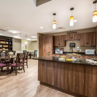 A modern kitchen and dining area with wooden cabinets and stylish lighting.