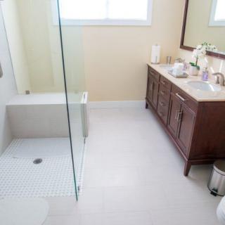 A modern bathroom with a glass shower and wooden vanity.