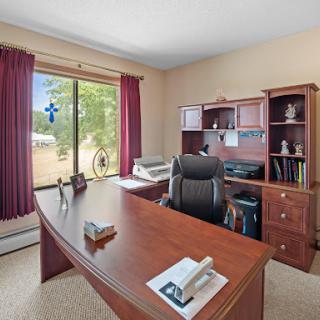 A well-organized home office featuring a wooden desk, ergonomic chair, and ample natural light.