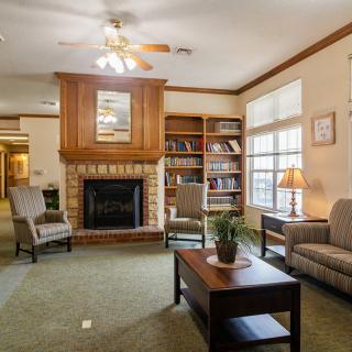 A cozy living room with a fireplace, bookshelves, and comfortable seating.
