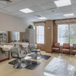 A bright and spacious hair salon interior with styling chairs and a waiting area.