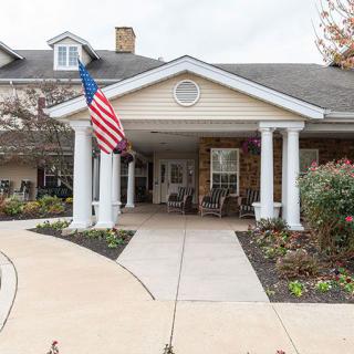 Entrance of a residential building with an American flag and landscaping.