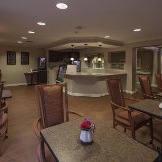 A cozy dining area with tables and chairs, softly lit for a welcoming atmosphere.