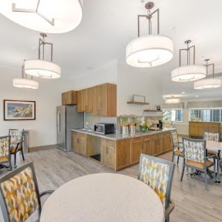 A modern kitchen and dining area featuring stylish light fixtures and comfortable seating.