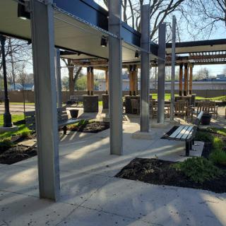 A serene outdoor space featuring a pavilion with benches and landscaped areas.