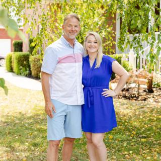 A happy couple posing together in a sunny garden.