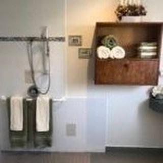 A well-organized bathroom with neatly arranged towels and a shower area.
