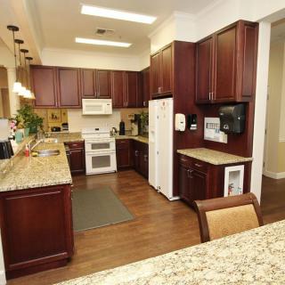 A modern kitchen with granite countertops and wood cabinetry.