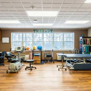 A well-equipped physical therapy clinic featuring exercise equipment and therapy tables.