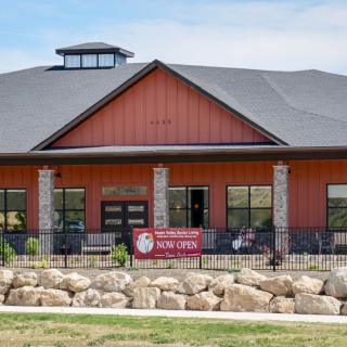 A newly opened business with a red facade and stone accents.