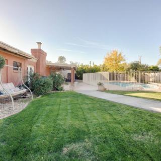 A serene backyard featuring a well-maintained lawn, pool, and patio area.